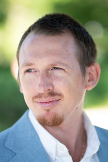 Brandon Kelly, photographed outdoors in a light jacket and open collar.